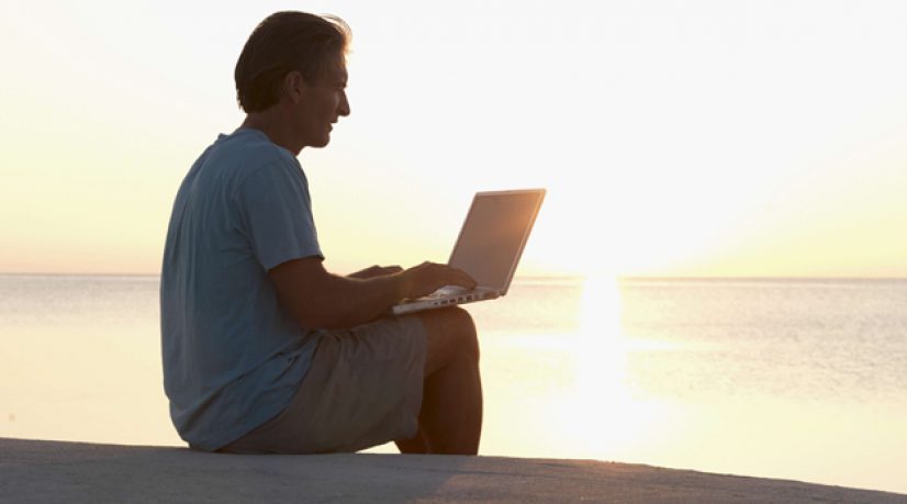 Homme surfant sur internet avec coucher de soleil
