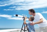 Enfant et père regardant à la jumelle