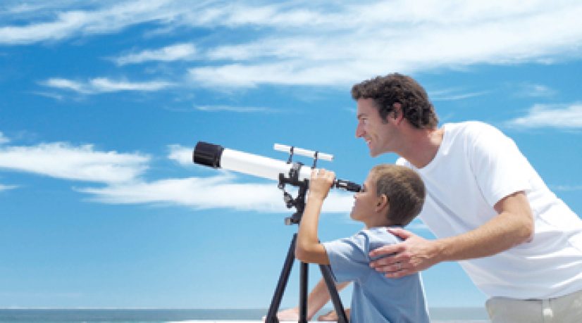 Enfant et père regardant à la jumelle